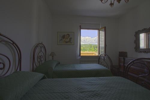 1 dormitorio con 2 camas y ventana en Casa Vì - Toscana, Lunigiana, near Cinque Terre, en Fivizzano