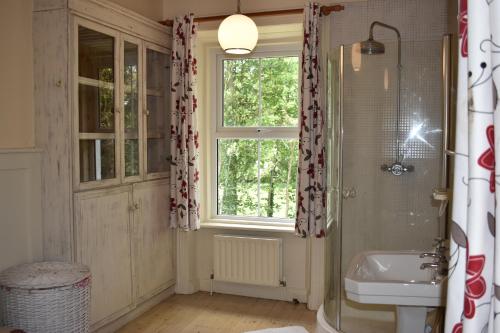 baño con ducha, lavabo y ventana en Church View Manor en Tullynamalra Cross Roads