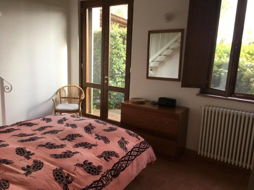 a bedroom with a bed and a dresser and a mirror at Stalla Lunga in Magliano in Toscana