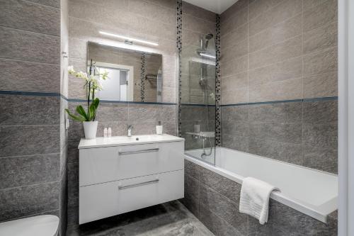 La salle de bains est pourvue d'un lavabo, d'une baignoire et de toilettes. dans l'établissement Flow Apartments Toruń, à Toruń