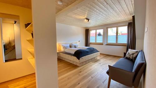 a bedroom with a bed and a couch and a window at Haus Akelei in Fischen