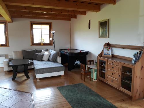 ein Wohnzimmer mit einem Sofa und einem Billardtisch in der Unterkunft Chata Liptovská Mara in Liptovský Trnovec