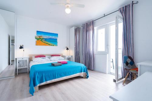 a bedroom with a bed with a blue blanket at Stara Baska Apartments in Stara Baška