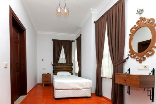 a bedroom with a bed and a mirror and a dresser at Pera Boutique Hotel in Antalya