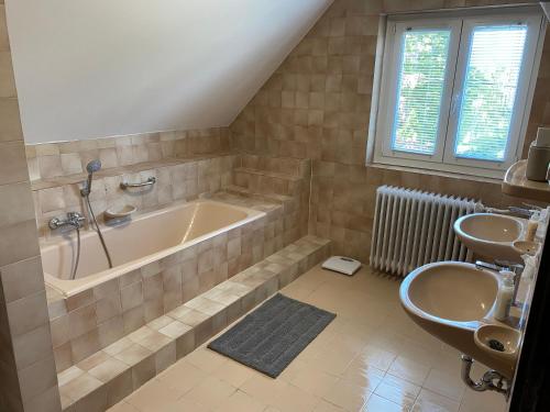 een badkamer met een ligbad en een wastafel bij Szomszéd Ház in Keszthely