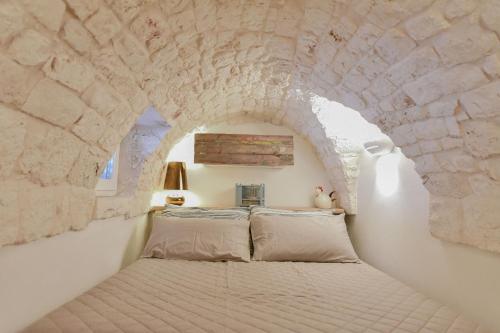 ein Schlafzimmer mit einem Bett in einer Steinmauer in der Unterkunft Chianca Bianca in Ostuni
