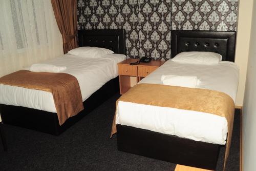 two beds in a hotel room withskirts at Kervan Hotel Pendik in Istanbul