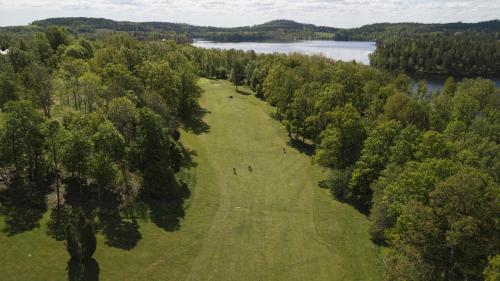people standing in a field next to a lake at Fredensborgs Herrgård in Vimmerby