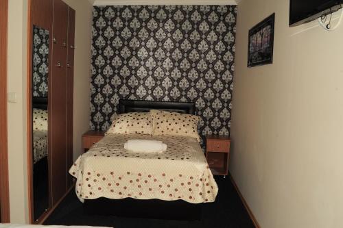 a small bedroom with a bed with a wall at Kervan Hotel Pendik in Istanbul