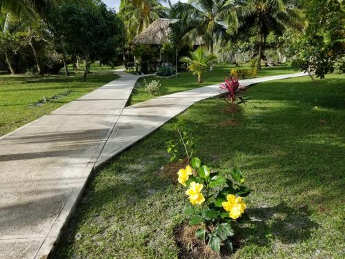 a walkway in a park with flowers in the grass at Nature Resort in Bermudian Landing