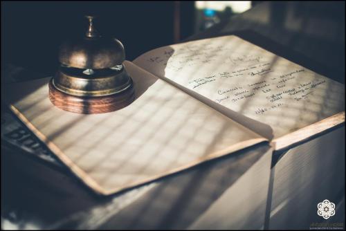 a bell sitting on top of a book with handwriting at Aktaion Hotel in Igoumenitsa