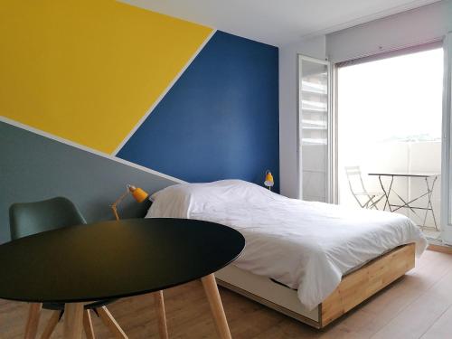 1 dormitorio con 1 cama con pared amarilla y azul en Studio vue imprenable, en Sierre