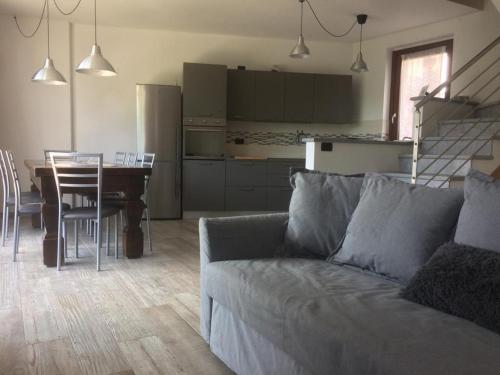 sala de estar con sofá, mesa y cocina en Ca' dul Sul, en Miazzina