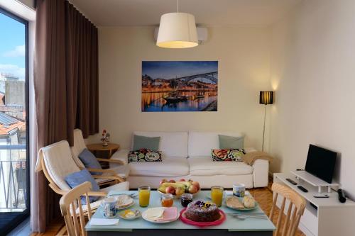 ein Wohnzimmer mit Sofa und Tisch mit Essen drauf in der Unterkunft Fabrica Apart in Porto