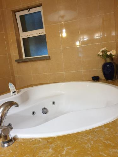 a white bath tub in a bathroom with a window at First In in Corroios