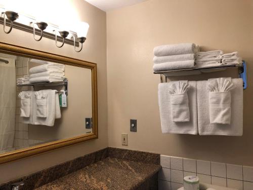 a bathroom with a mirror and white towels at Port Angeles Inn in Port Angeles