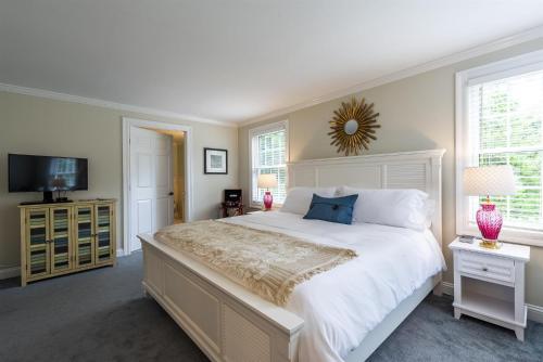 a bedroom with a large white bed and a television at The Homestead in Madison