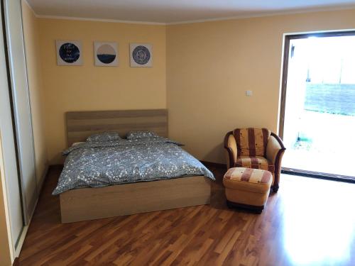 1 dormitorio con 1 cama, 1 silla y 1 ventana en Apartament Holiday, en Władysławowo