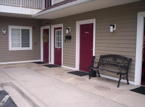 a porch with a bench and a red door at Affordable Suites Florence in Florence