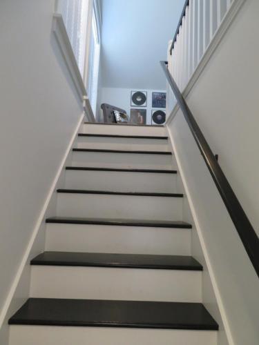 a stairway with white and black treads and white stairs at Devil's Lake Inn and Devil's Lake Inn Too in Manitou Beach