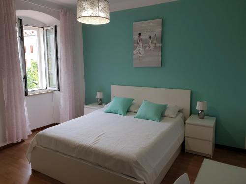 a bedroom with a large bed with blue walls at Guesthouse Fatuta in Cres