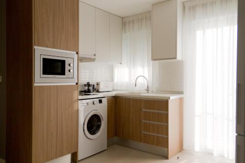 a kitchen with a washing machine and a microwave at Sosiego Home in Puerto de Mazarrón
