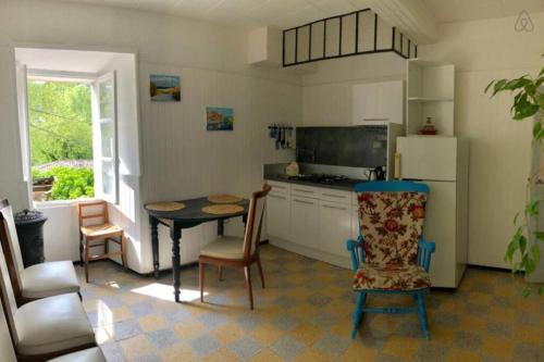 La cuisine est équipée d'une table, de chaises et d'un réfrigérateur. dans l'établissement Charmante maison de village à Fontaine-de-Vaucluse, à Fontaine-de-Vaucluse
