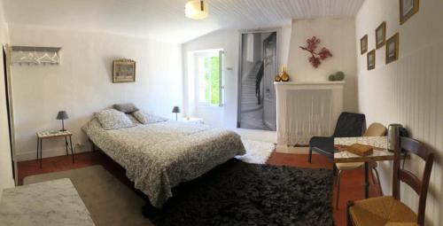 une chambre avec un lit, une table et une fenêtre dans l'établissement Charmante maison de village à Fontaine-de-Vaucluse, à Fontaine-de-Vaucluse