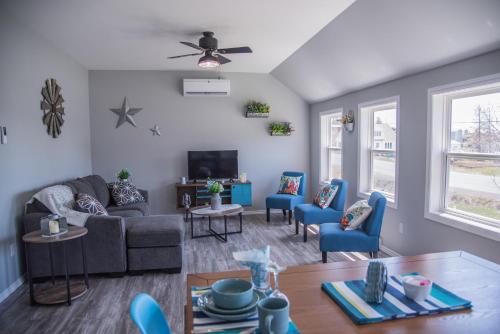 salon z kanapą i niebieskimi krzesłami w obiekcie Family Ties Vacation Home - Hopkins House w mieście Twillingate