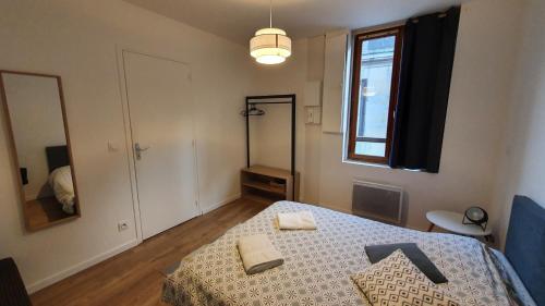 een slaapkamer met een bed met twee handdoeken erop bij Près des Bassins, Appartement 35m2 hyper centre Honfleur in Honfleur