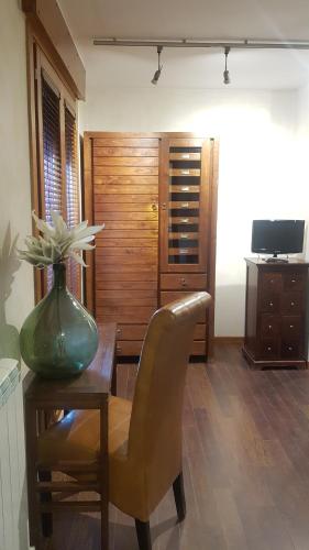 a vase sitting on a wooden table with a chair at Hostal Los Canteros in Golmayo