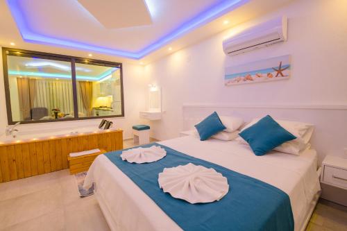 a bedroom with a large bed with blue pillows at MULBERRY SUİT APART in Kaş