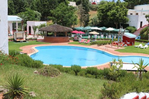 a large swimming pool with a gazebo at Hôtel Mandy in Tetouan