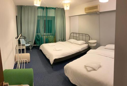 um quarto de hotel com duas camas e uma cadeira verde em green Apartment 96 em Bucareste