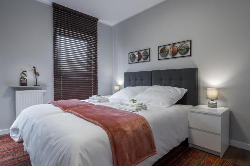 托倫的住宿－Flow Apartments Toruń，卧室配有一张带白色床单的大床和窗户。