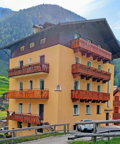 a large yellow building with red balconies on it at Casa vacanze Heidi e Peter Val di Rabbi in Rabbi