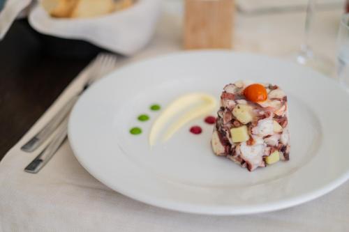a piece of food on a white plate on a table at Plana Resort & SPA in Castel Volturno