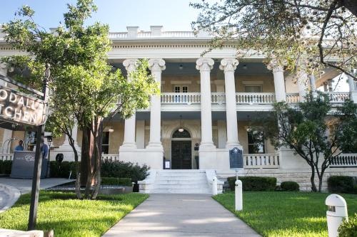 a large white building with columns and a sidewalk at Hotel Ella in Austin