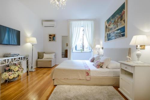 a white bedroom with a bed and a living room at Guest House Flores in Dubrovnik