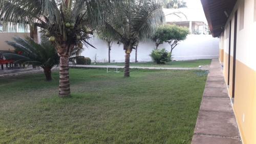 two palm trees in a yard next to a building at Pousada Nosso Recanto Camocim in Camocim