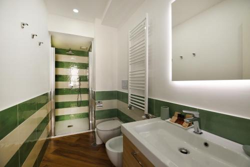 La salle de bains est pourvue d'un lavabo, de toilettes et d'un miroir. dans l'établissement The Wanderlast Sorrento, à Sorrente