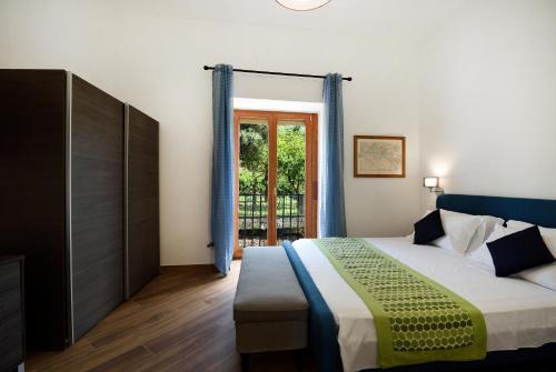 - une chambre avec un lit et une porte coulissante en verre dans l'établissement The Wanderlast Sorrento, à Sorrente