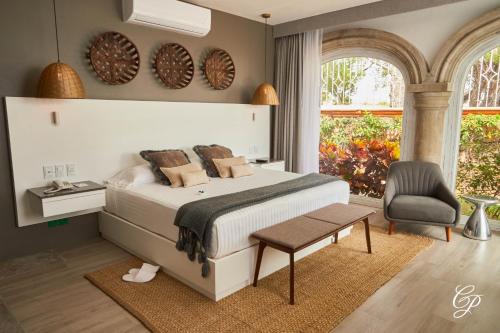 a bedroom with a bed and a chair at Hotel Boutique de Cantera Y Plata in Taxco de Alarcón