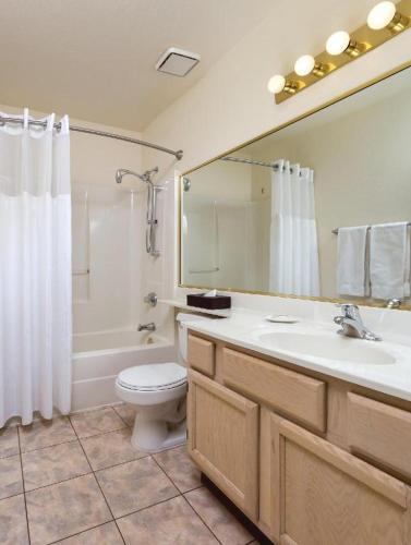 a bathroom with a sink and a toilet and a mirror at GetAways at Havasu Dunes Resort in Lake Havasu City