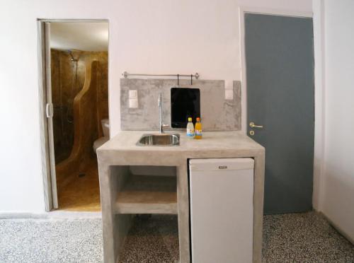 a kitchen with a sink and a mirror at stamatia's rooms in Agios Kirykos
