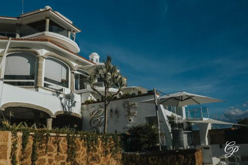 a white house with an umbrella in front of it at Hotel Boutique de Cantera Y Plata in Taxco de Alarcón