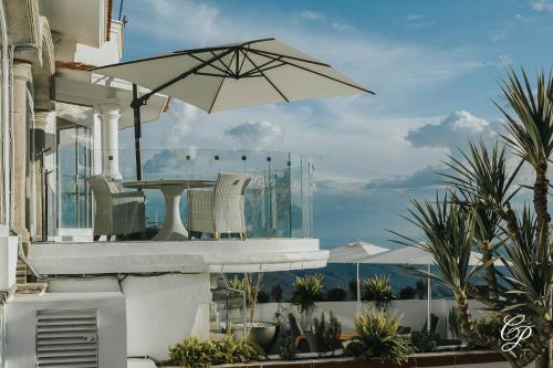a patio with a table and chairs and an umbrella at Hotel Boutique de Cantera Y Plata in Taxco de Alarcón