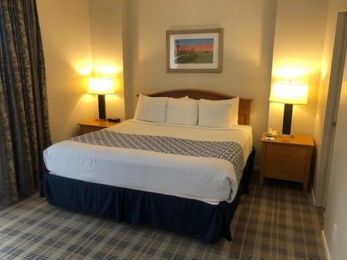 a hotel room with a large bed and two lamps at GetAways at Vista Mirage Resort in Palm Springs
