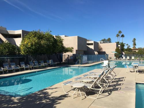 a swimming pool with lounge chairs and a swimming pool at GetAways at Vista Mirage Resort in Palm Springs
