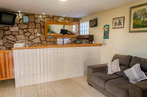 een lobby met een bar met een stenen muur bij Pousada Beira Rio in Santo Antônio do Pinhal